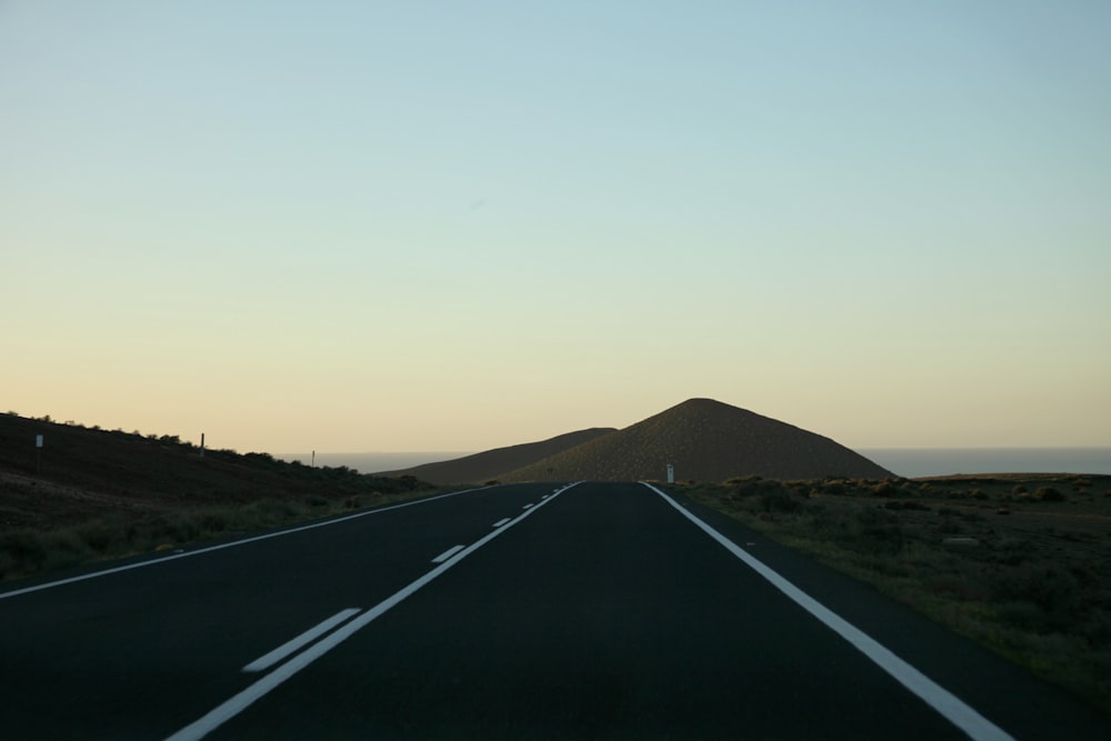 a road with a hill in the background