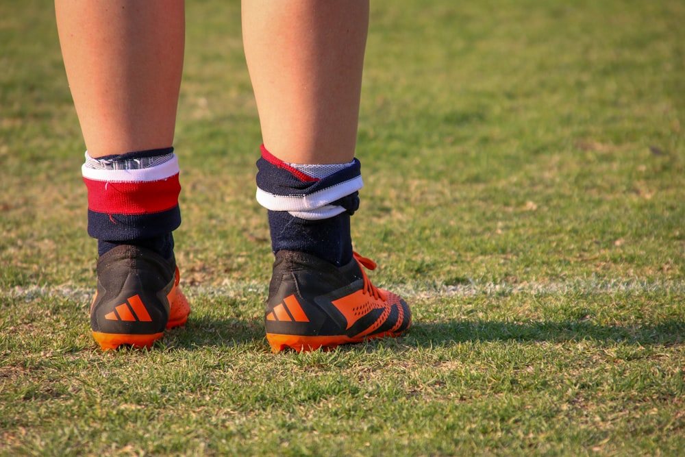 Eine Nahaufnahme der Beine einer Person, die Fußballschuhe trägt