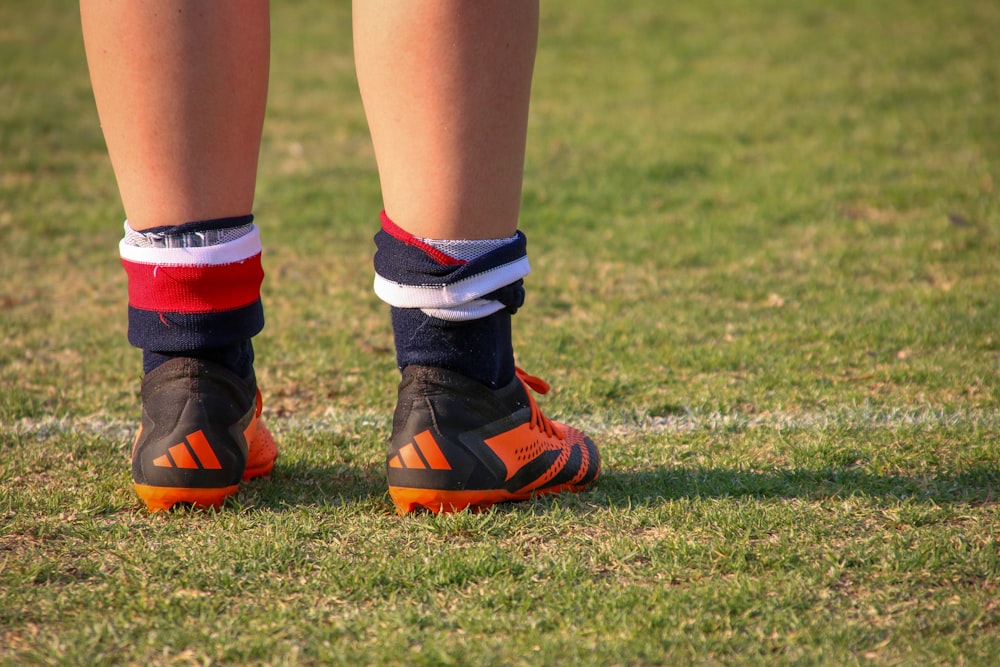 a close up of a person's legs wearing soccer shoes