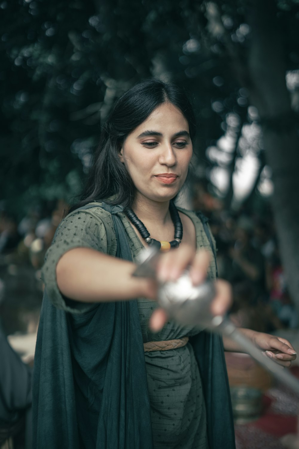 a woman in a green dress holding a metal object