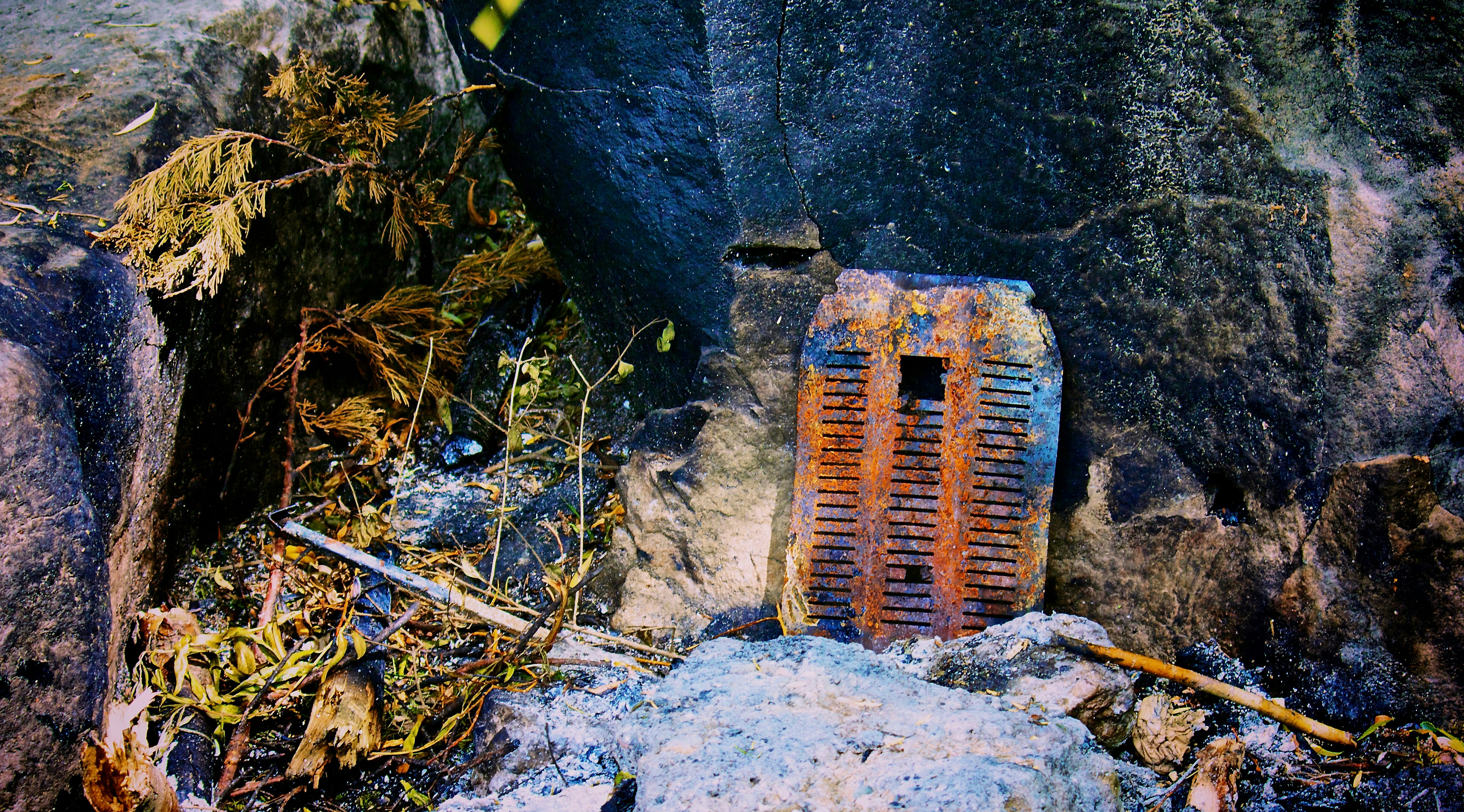 eine verrostete Außentür, die auf einem Felsen sitzt