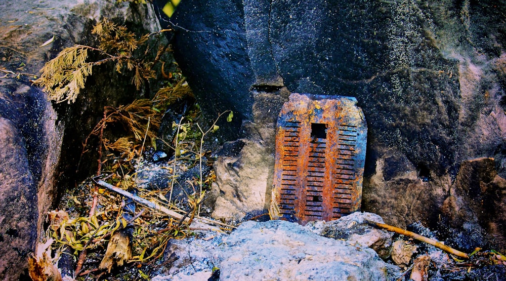 a rusted out door sitting on top of a rock