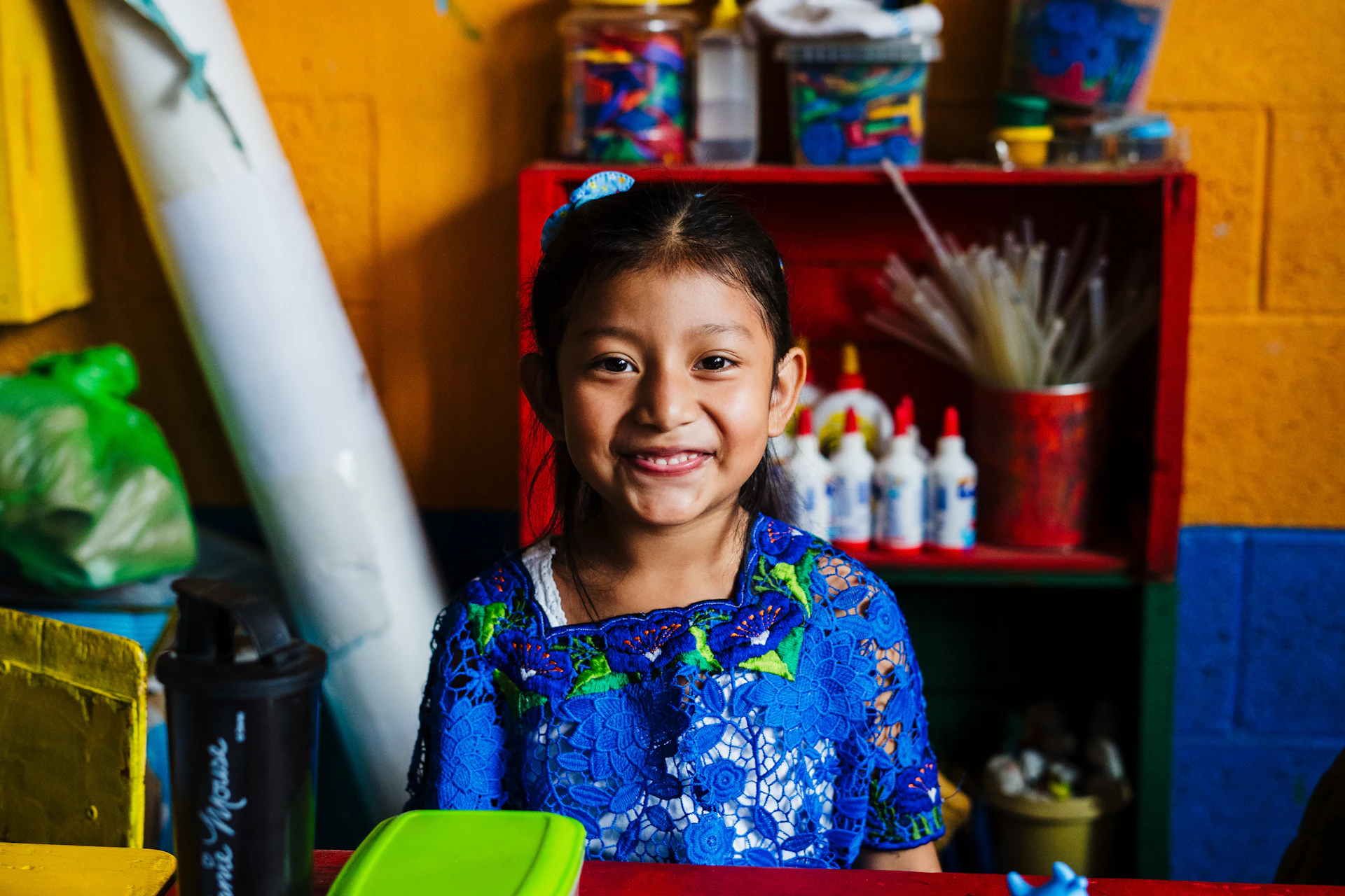 a young girl sitting in front of a surfboard