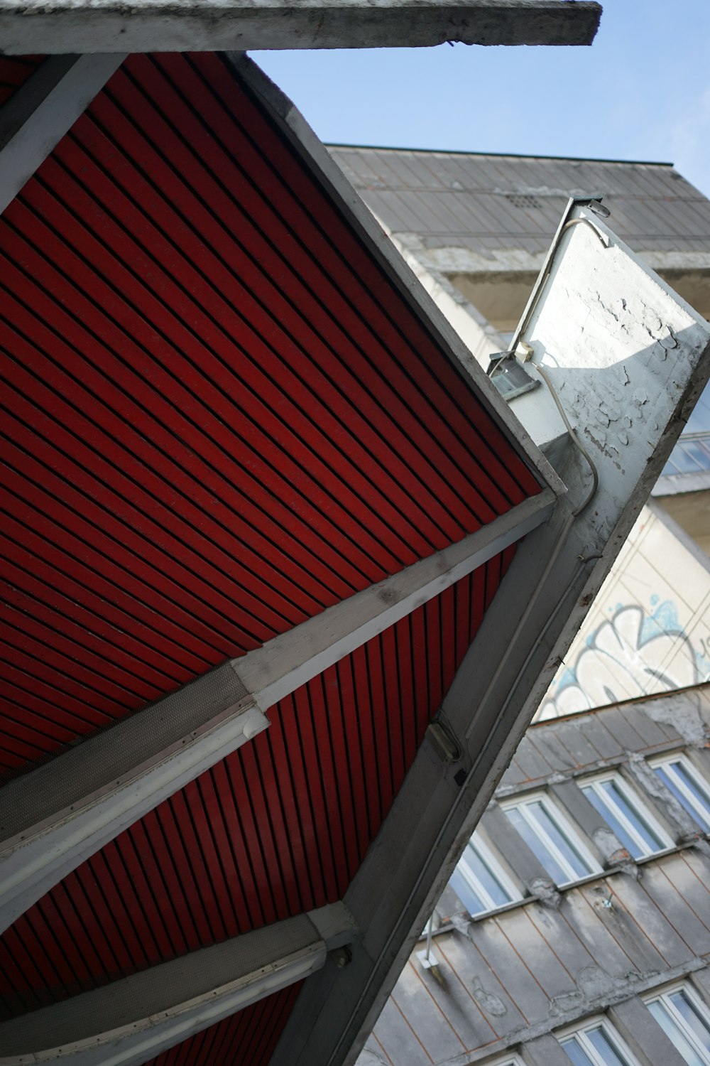 a close up of a red roof with a building in the background