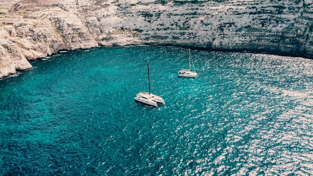 a couple of boats floating on top of a body of water