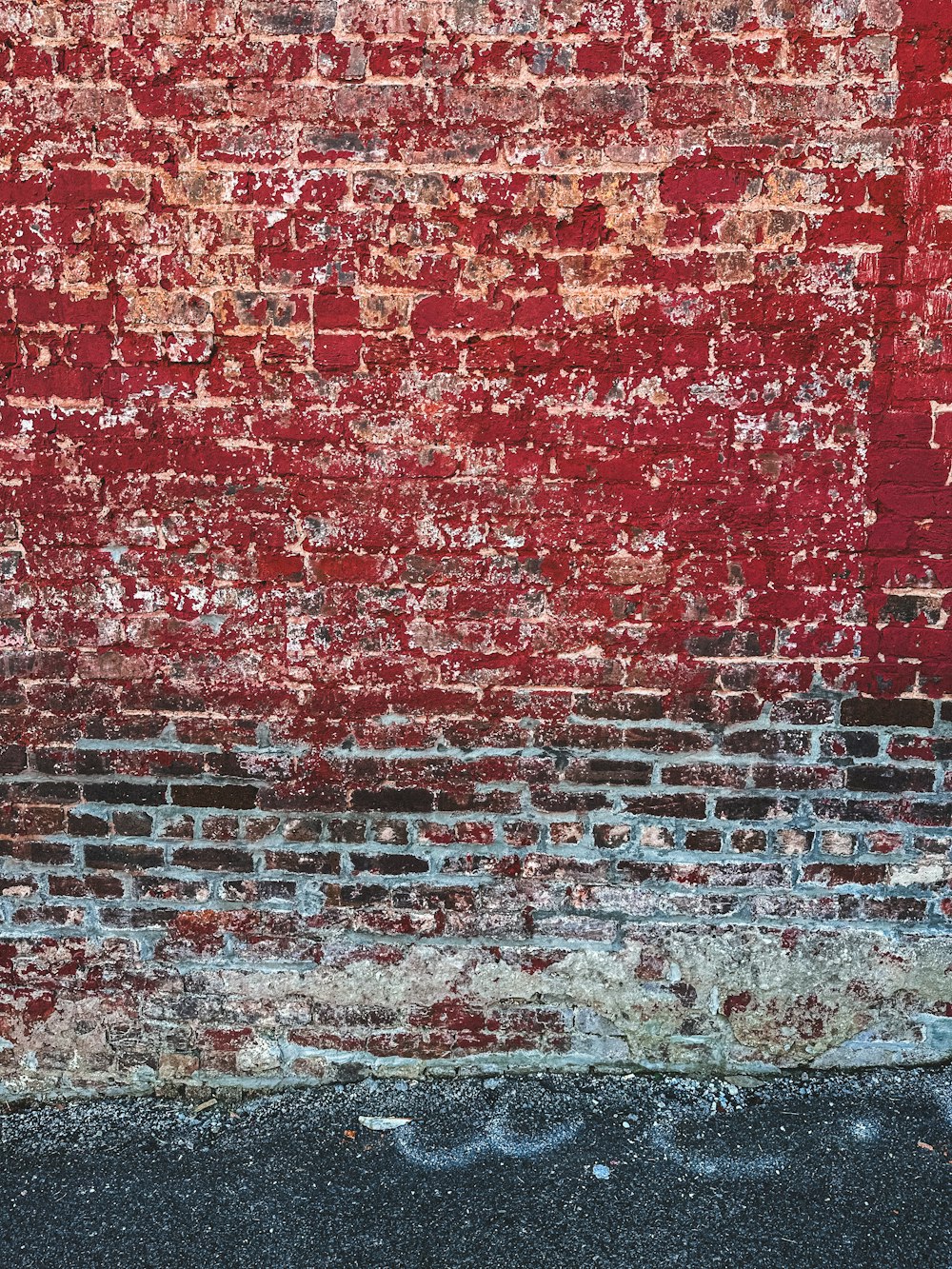 a red brick wall with a fire hydrant in front of it