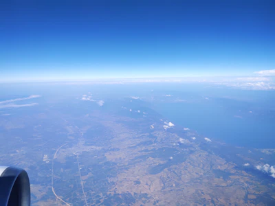 A serene view from the airplane window showing the vast Indian landscape below.