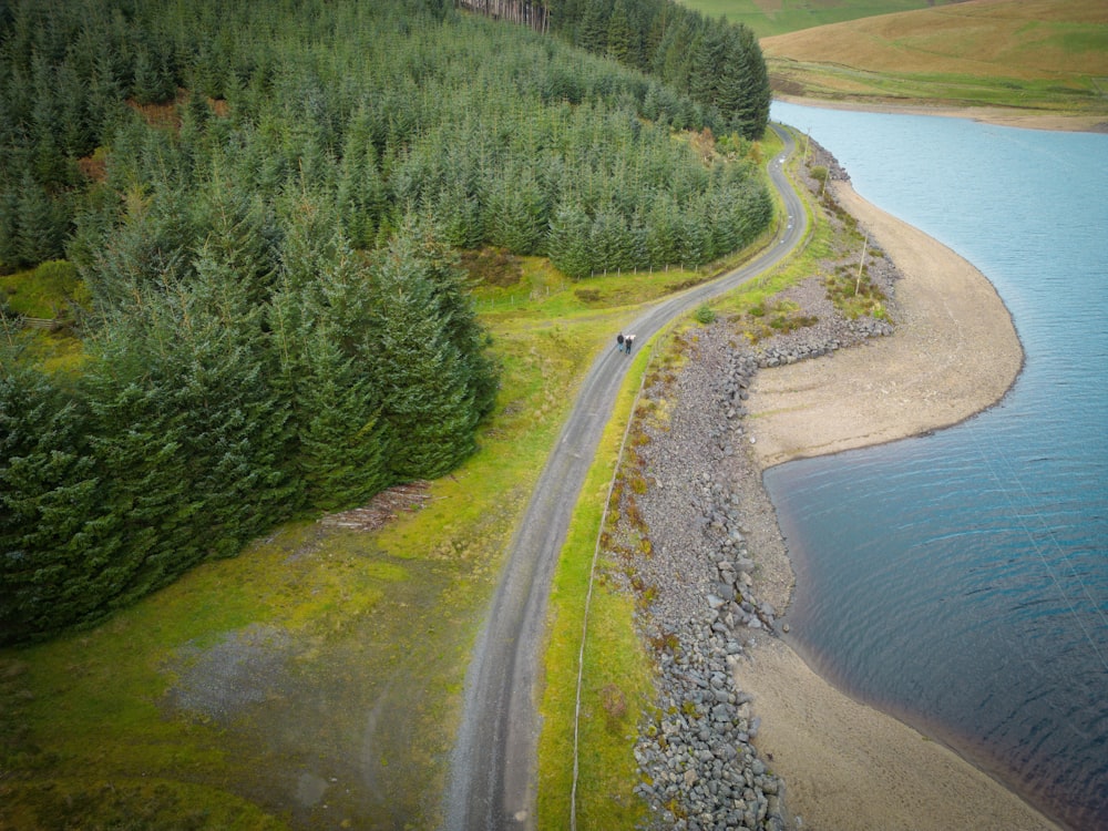 a car driving down a road next to a lake