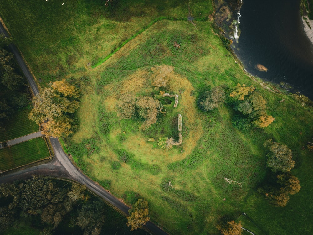 an aerial view of a grassy area with a river in the background