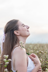 Smiling woman enjoying a moment of mental wellness in a peaceful setting.