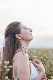 A serene woman meditating in a peaceful garden surrounded by blooming flowers.