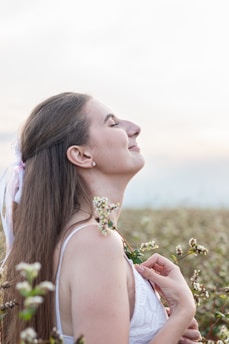 A serene woman meditating in a peaceful garden surrounded by blooming flowers.