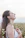 Smiling woman enjoying a peaceful moment in nature, radiating calm and wellness.