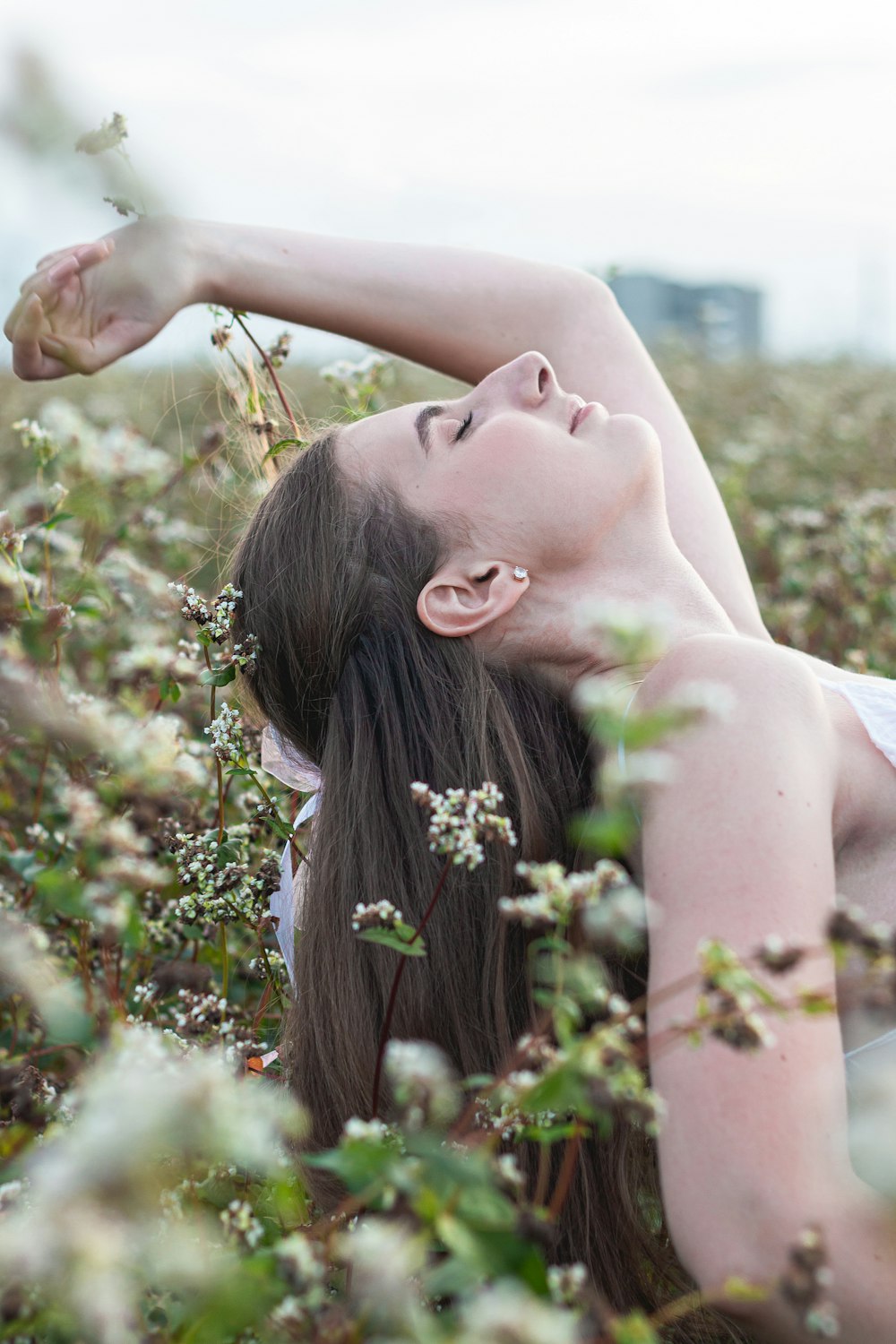 a woman laying down in a field of flowers