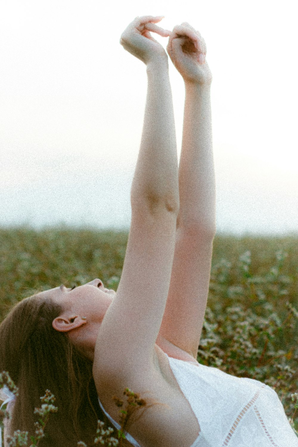 a woman in a white dress laying in a field
