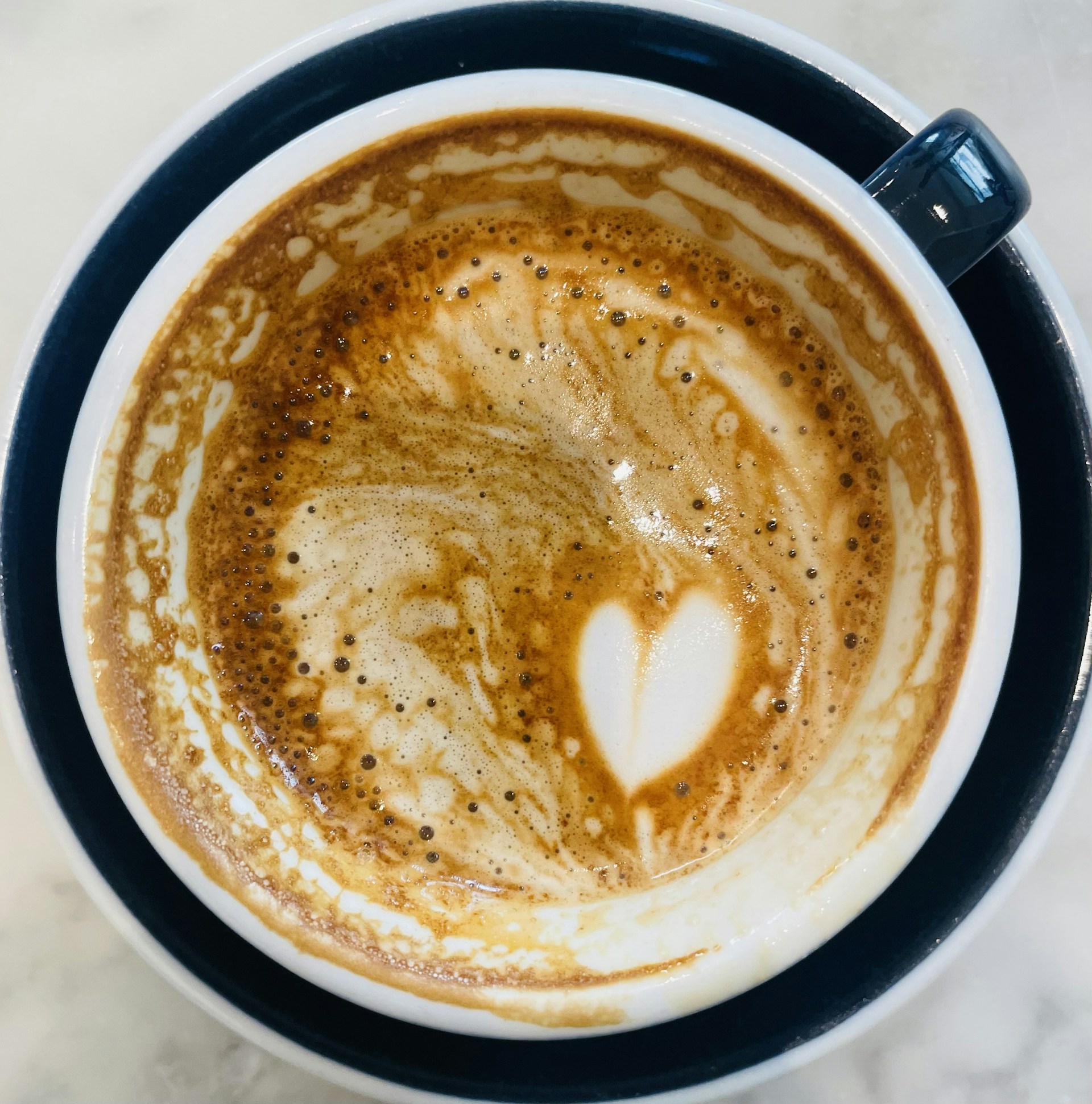 Close-up of a creamy cappuccino with latte art served in a rustic ceramic cup at Cafe Villa.