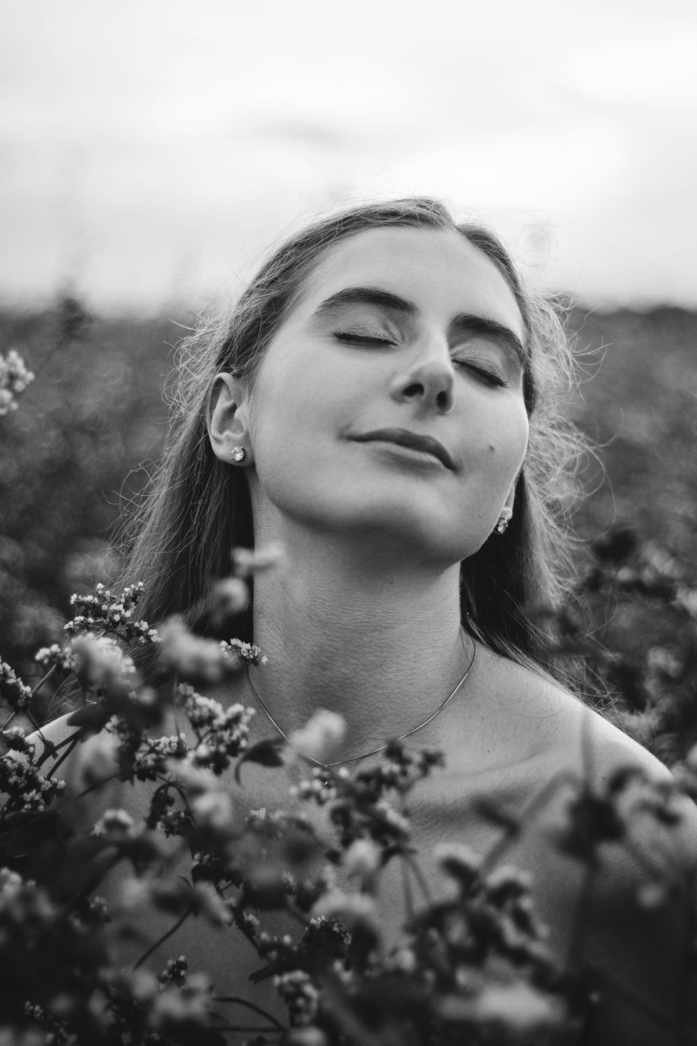 a woman in a field of flowers with her eyes closed