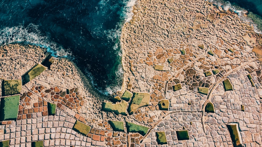 an aerial view of a cobblestone beach and ocean