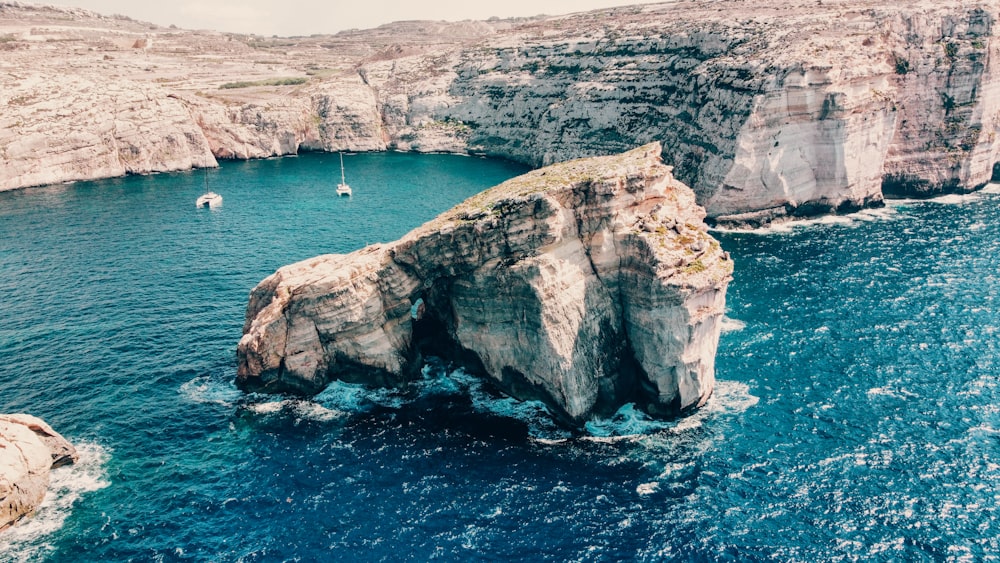 a large rock in the middle of a body of water