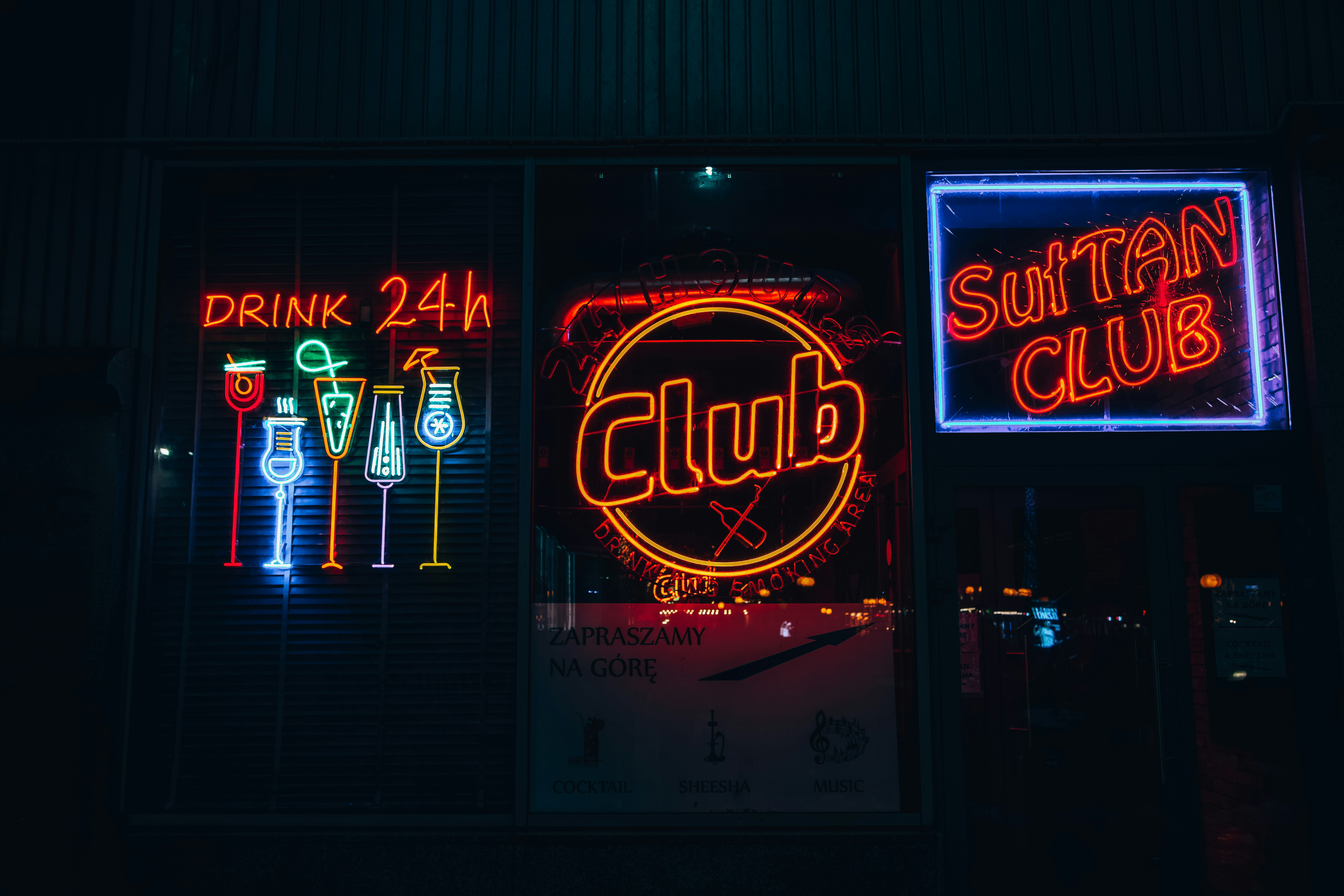 a group of neon signs that are on the side of a building