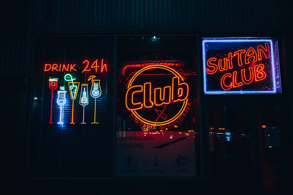 a group of neon signs that are on the side of a building