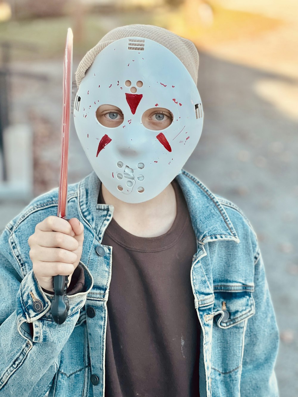 a boy wearing a mask holding a baseball bat