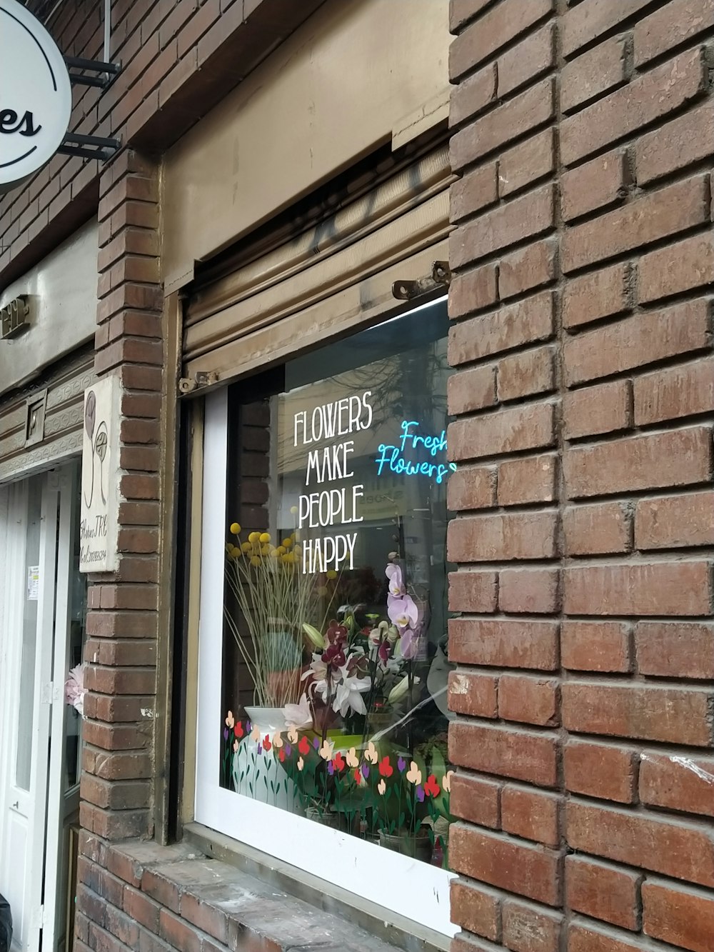 a brick building with a flower shop sign in the window