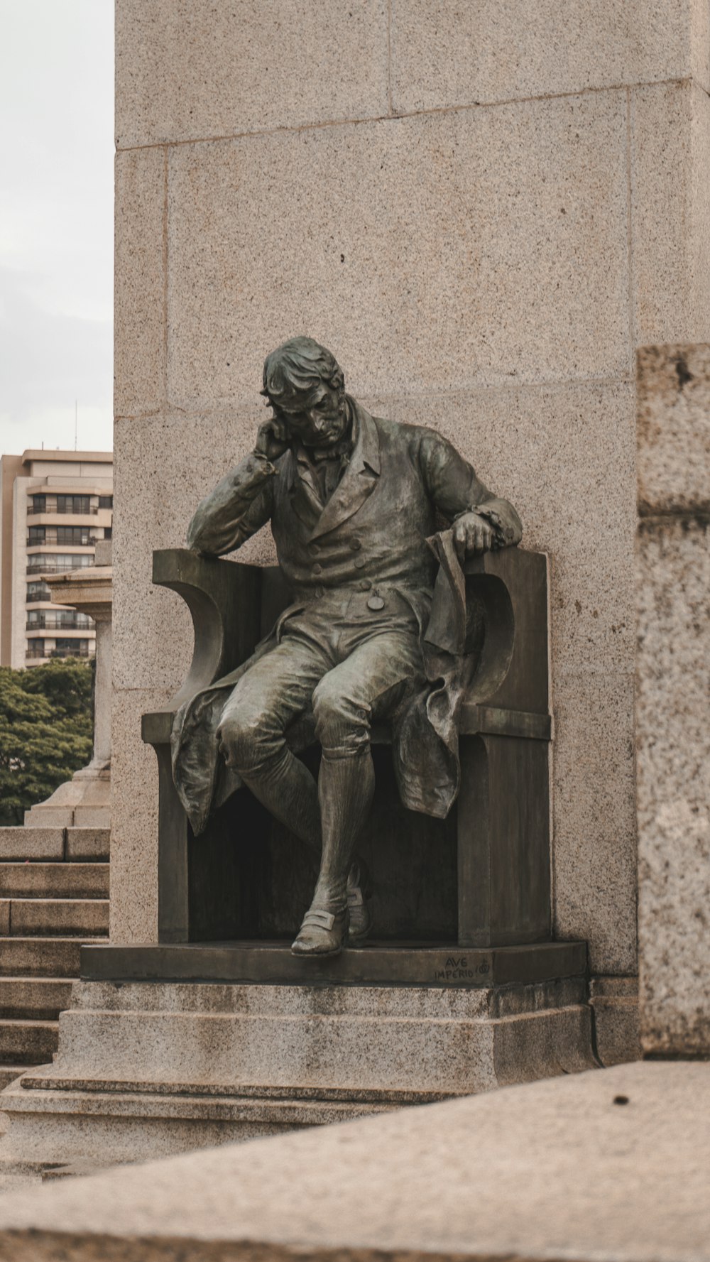 a statue of a man sitting in a chair