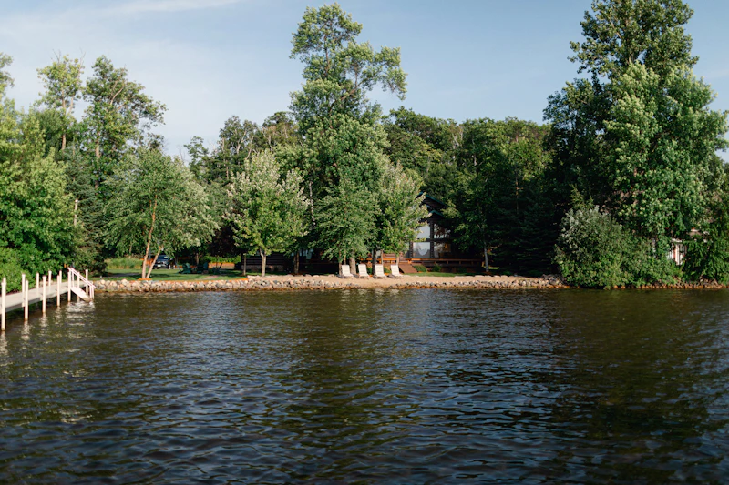 Wooden dock extending over calm lake water surrounded by trees