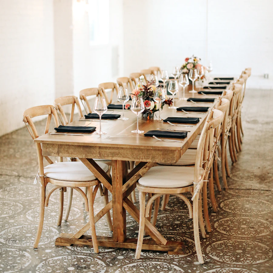 Longue table en bois avec des chaises et des couverts dressés