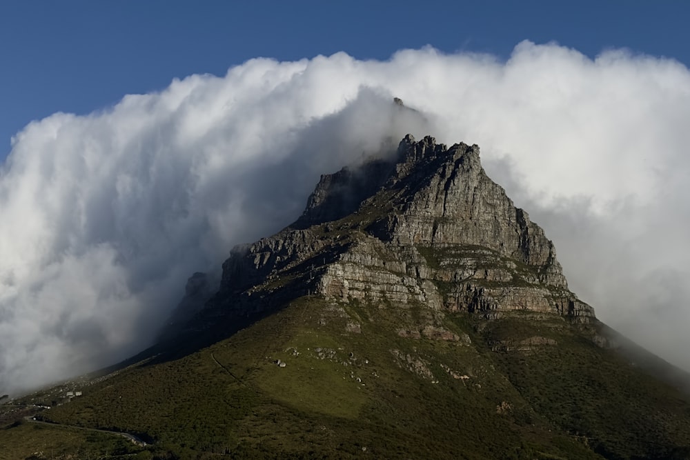 a very tall mountain with some clouds in the sky