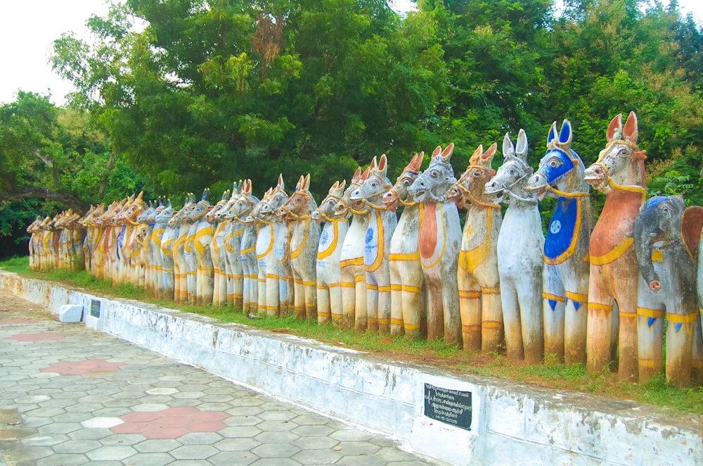 a long row of wooden statues of horses