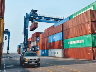 A cargo container being loaded onto a truck at a warehouse.