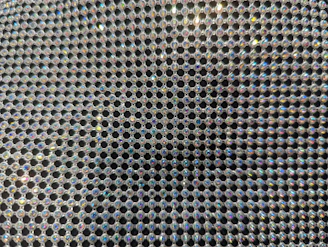Close-up of a sparkling rhinestone design applied on a black hoodie fabric.