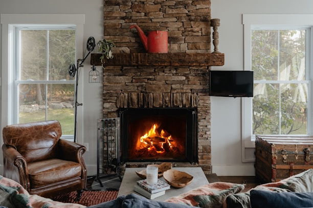 A cozy living room featuring a decorative fire vase glowing warmly on a wooden table.