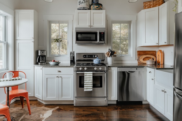 A bright kitchen scene with a stainless steel microwave oven on the countertop.