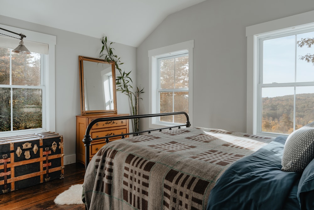 a bedroom with a bed, dresser and window