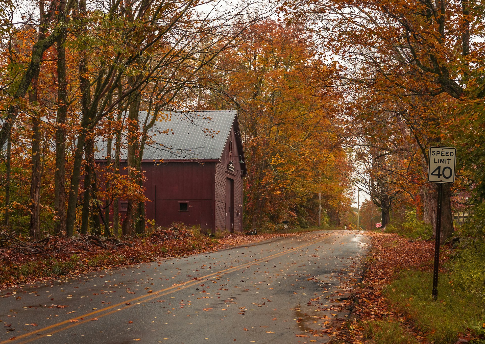 a country road with a barn in the background