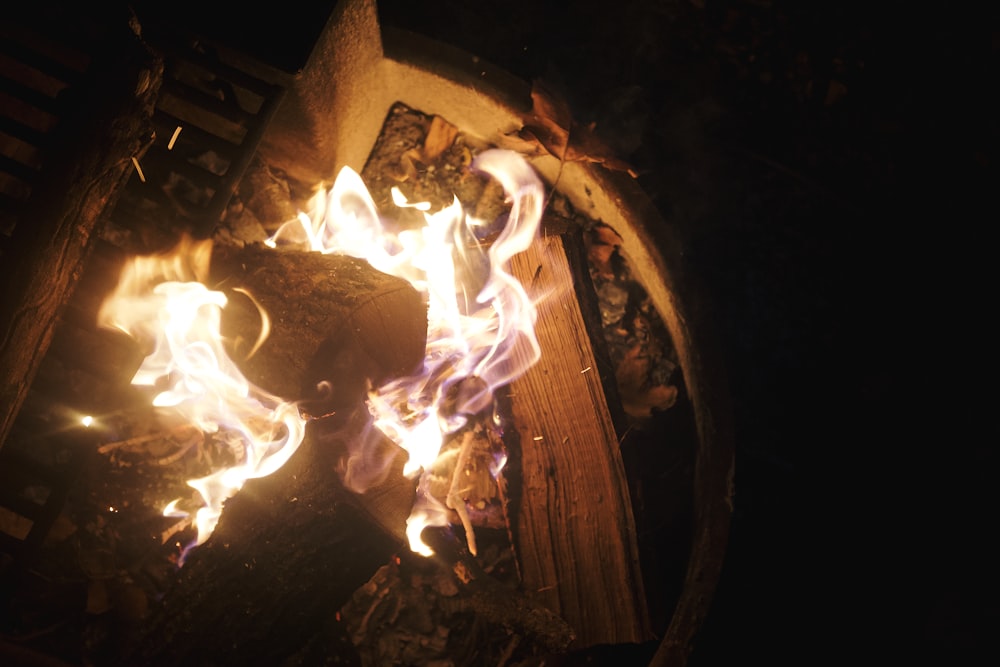 um fogo queimando em uma lareira com chamas saindo dela