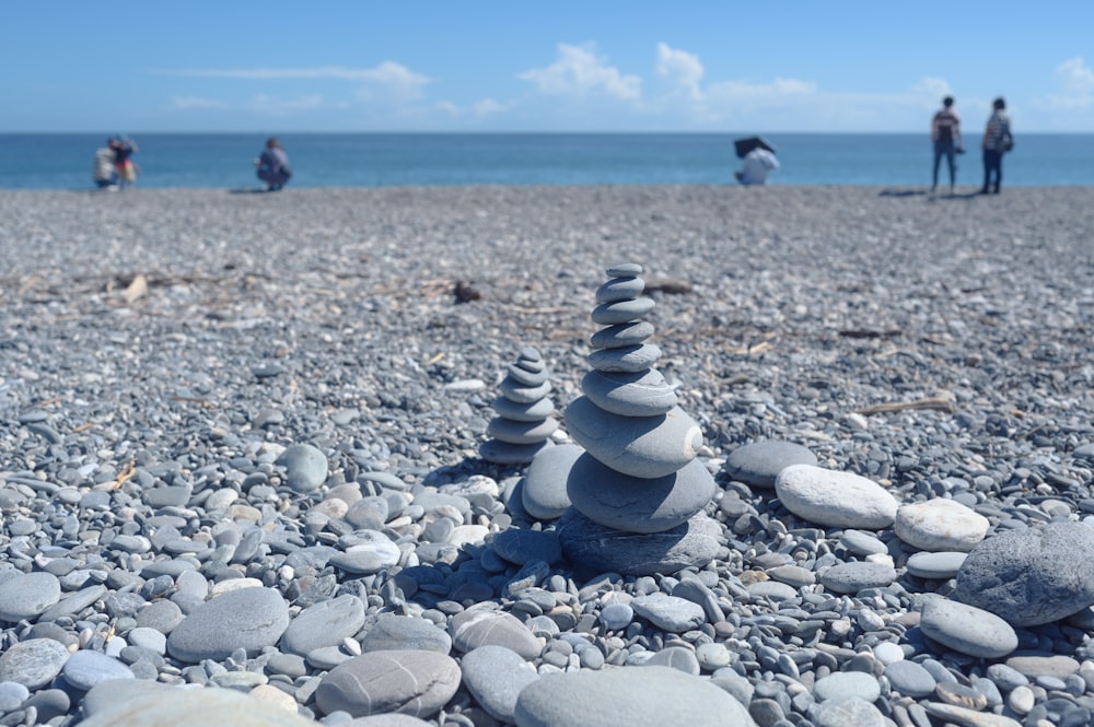 un mucchio di rocce seduto sulla cima di una spiaggia