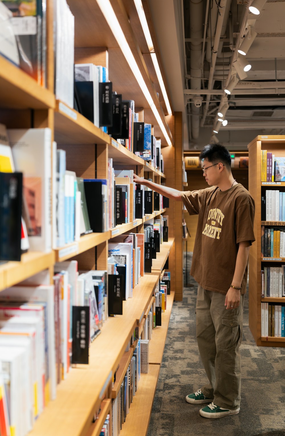a man standing in front of a book shelf filled with books