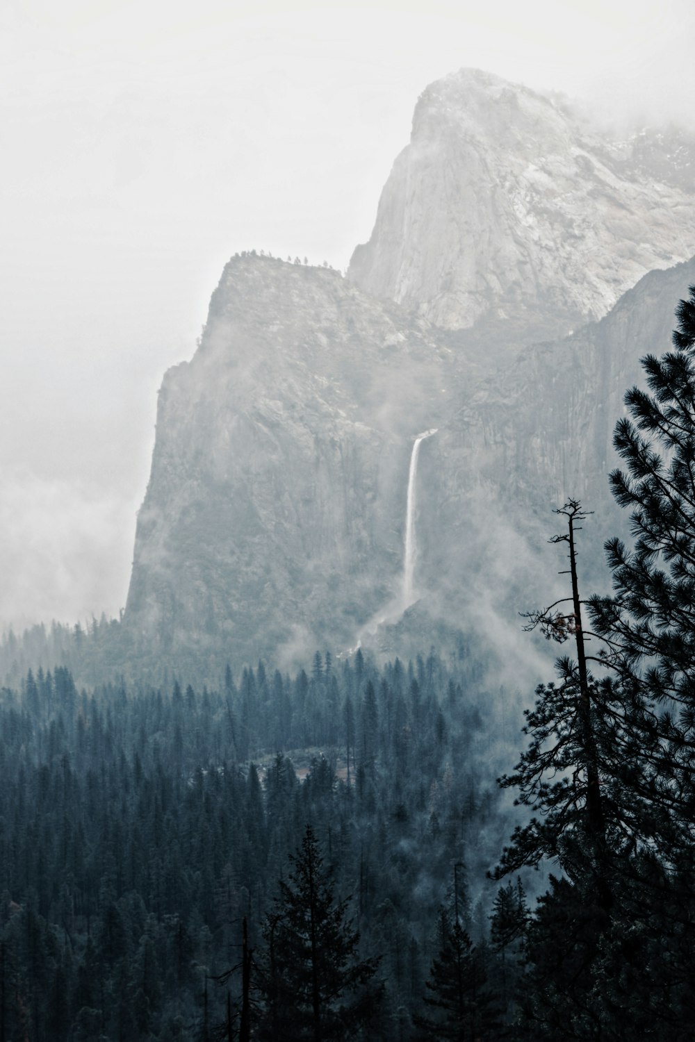 a tall mountain with a waterfall coming out of it