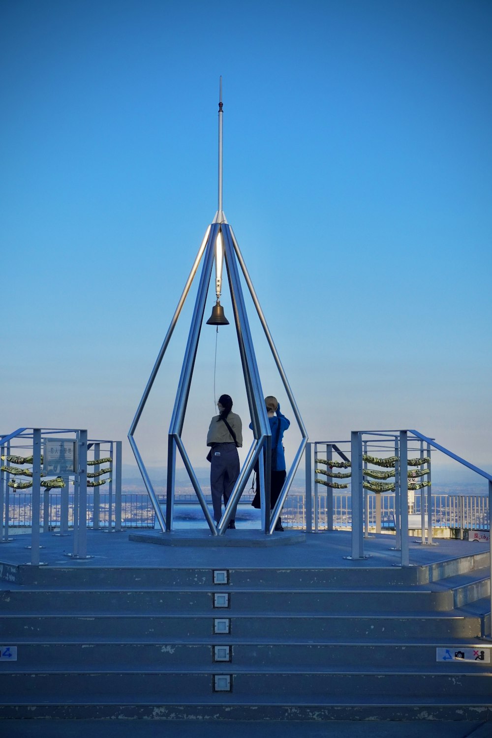 a couple of people standing on top of a metal structure