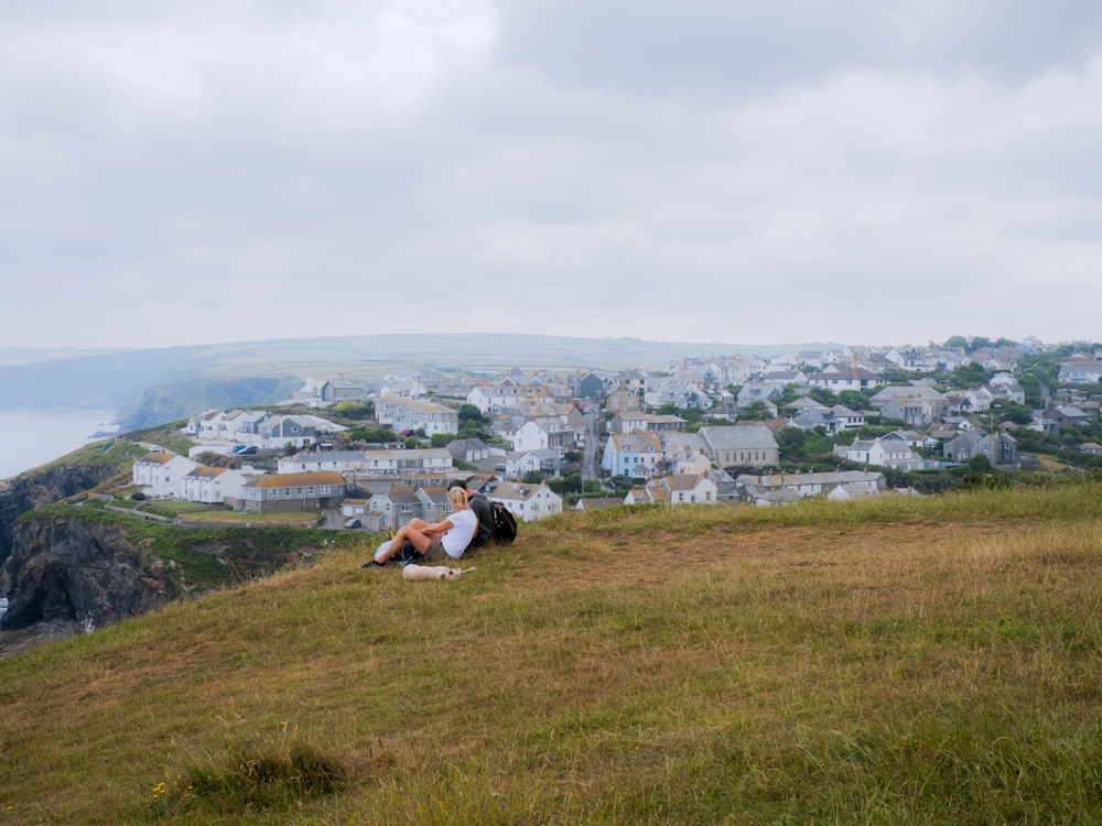 a person sitting on a hill overlooking a town