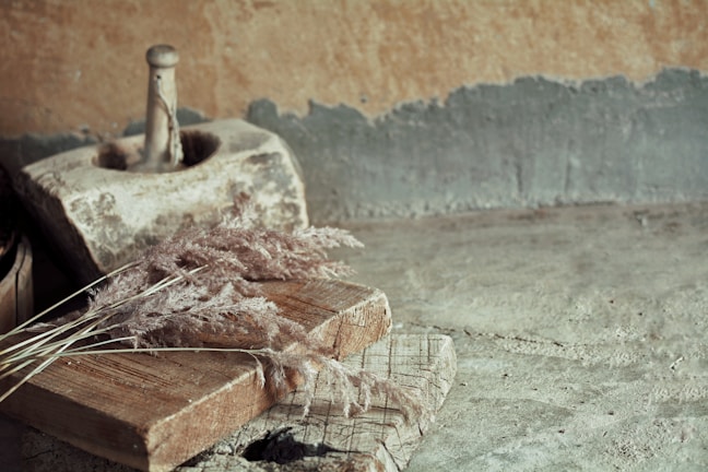 Close-up of a rustic stone mortar and pestle on a wooden countertop.