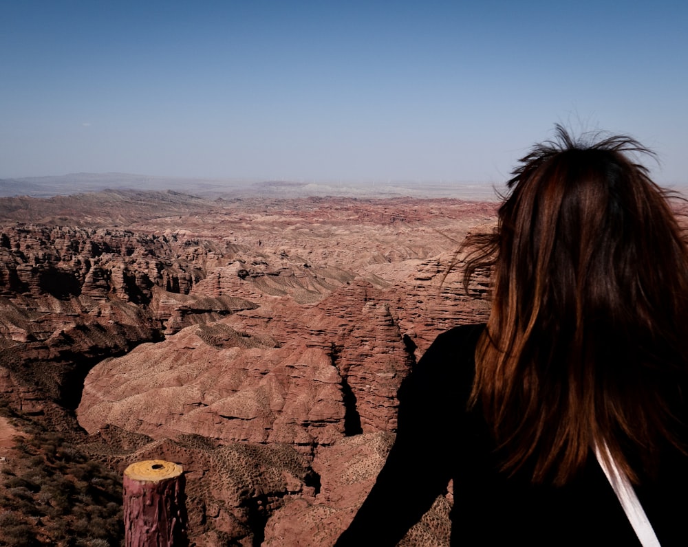 a woman standing on top of a rocky cliff