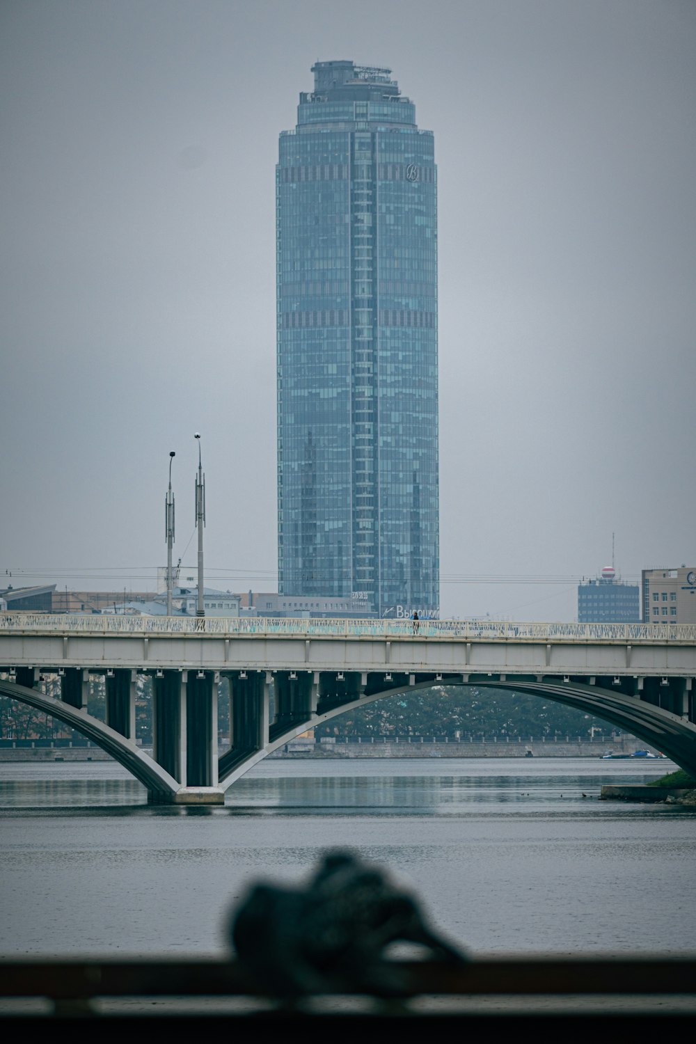 a bridge over a body of water with a tall building in the background