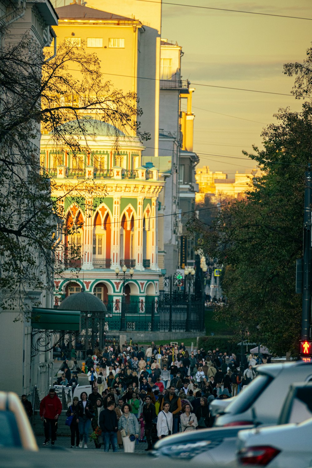 a crowd of people walking down a street next to tall buildings