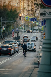 a man riding a bike down a street filled with traffic