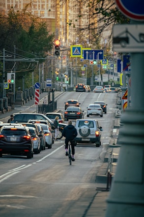 a man riding a bike down a street filled with traffic